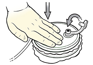 Primer plano de una mano enguantada que vacía el líquido del drenaje Hemovac en un recipiente de medición.